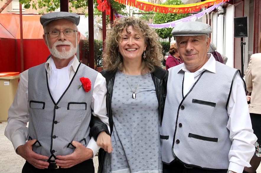 Participantes vestidos de chulapos con una de las responsables del centro