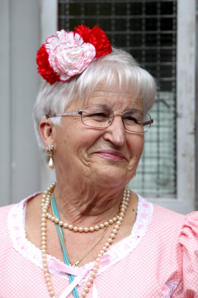 Señora sonriente con claveles en el pelo