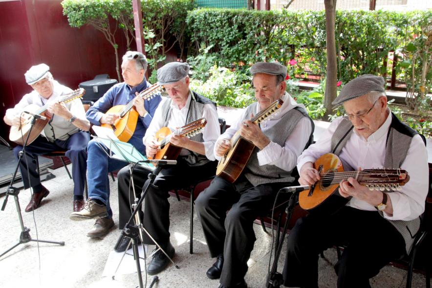 Señores vestidos de chulapos tocando la mandolina