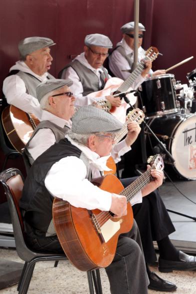 Señores tocando la guitarra vestidos de chulapos