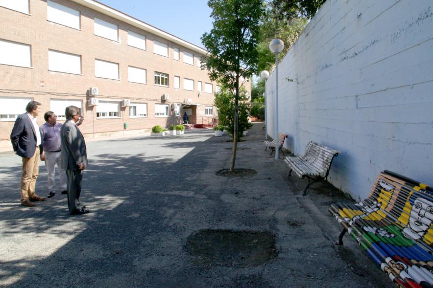 Visita al IES Giner de los Ríos - Imagen del alcalde García de Vinuesa y otras autoridades mirando los bancos que han decorado los alumnos en el patio.