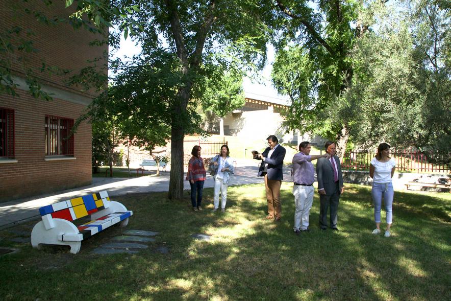 Visita al IES Giner de los Ríos - Imagen del alcalde García de Vinuesa y otras autoridades mirando los bancos que han decorado los alumnos en el patio.