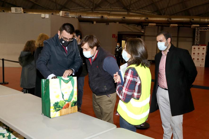 Delegación municipal observa el contenido de una bolsa durante la visita