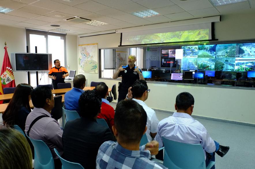 Visita Alumnos EGME a Policía Local - Imagen de un policía dirigiéndose a los visitantes a sus instalaciones y también asiste un representante de protección civil.