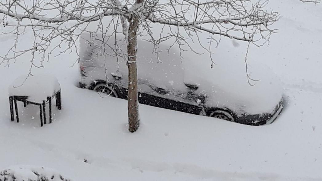 Coche y mesa completamente cubiertos de nieve