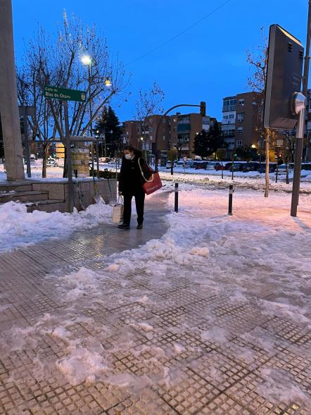 Ciudadano cruzando un paso abierto entre la nieve