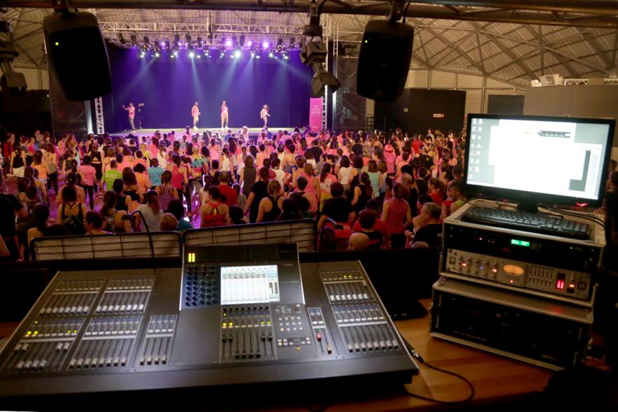 Masterclass Zumba Solidario AECC - Imagen desde la cabina DJ se ve público asistente y profesores en el escenario.