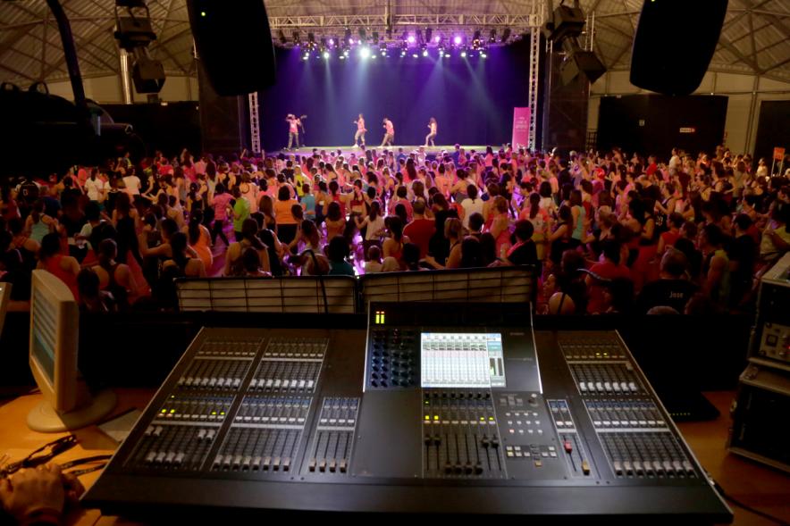 Masterclass Zumba Solidario AECC - Imagen desde la cabina DJ se ve público asistente y profesores en el escenario.