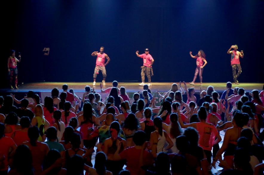 Masterclass Zumba Solidario AECC - Imagen profesores de zumba dando clase desde el escenario al público asistente.