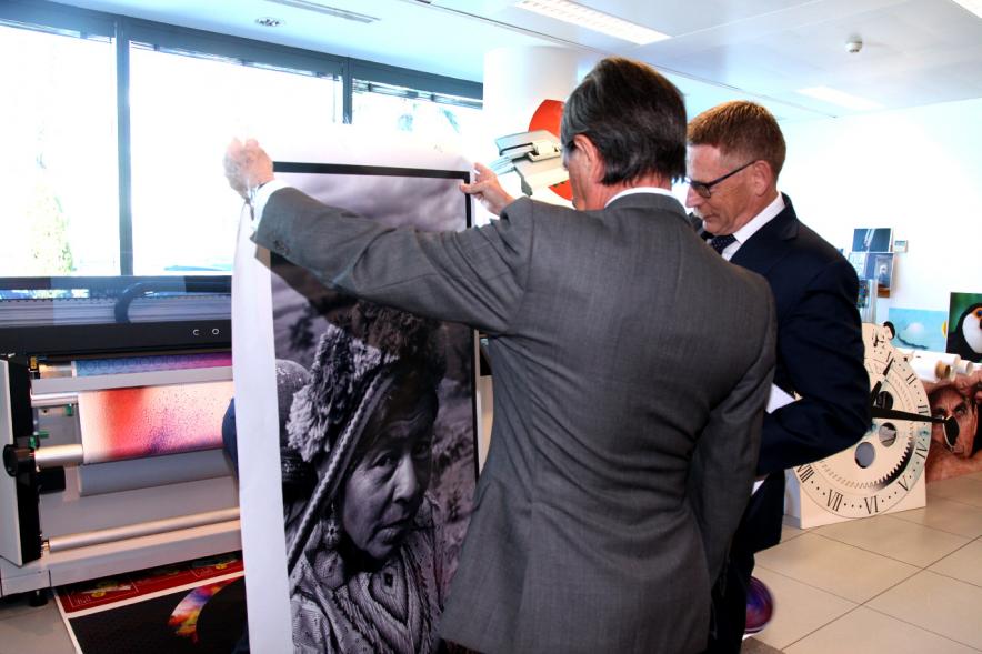 Alcalde y representante de Canon observan una impresión digital