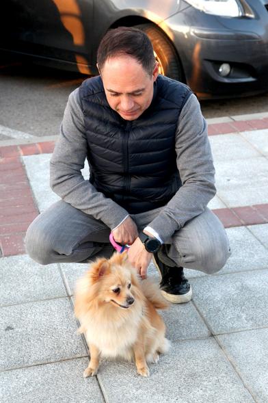Bendición de Animales por San Antón en la Parroquia San Juan XXIII - Imagen primer plano de un perro con su dueño en el exterior de la iglesia.