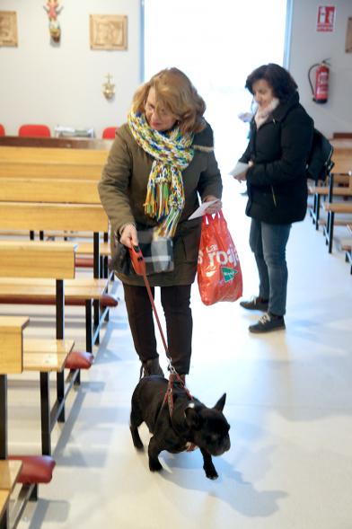 Bendición de Animales por San Antón en la Parroquia San Juan XXIII - Imagen de una persona entrando en la iglesia con su perro.