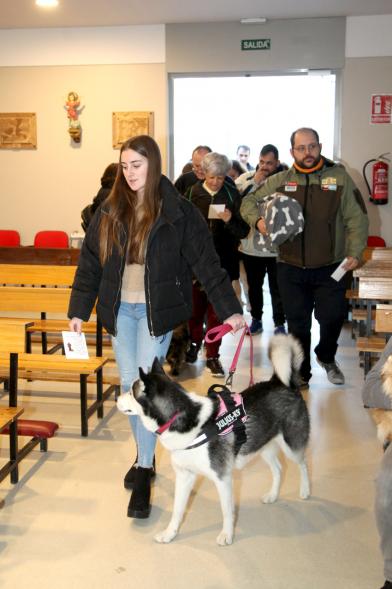 Bendición de Animales por San Antón en la Parroquia San Juan XXIII - Imagen de una persona entrando en la iglesia con su perro.