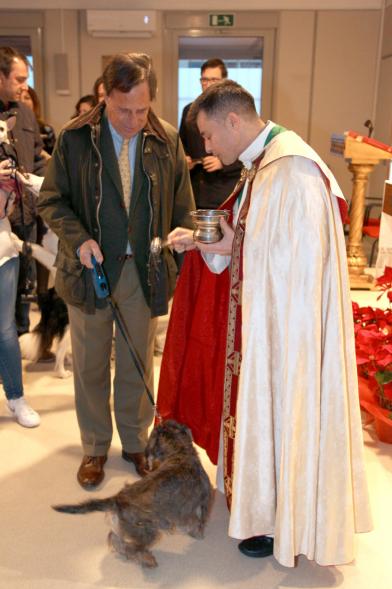 Bendición de Animales por San Antón en la Parroquia San Juan XXIII - Imagen del Alcalde García de Vinuesa  acercando su perro para que el cura le bendiga.