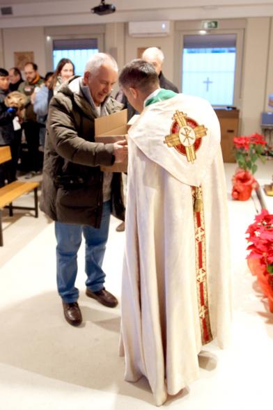 Bendición de Animales por San Antón en la Parroquia San Juan XXIII - Imagen de una persona acercando su mascota en una caja para que el cura le bendiga.