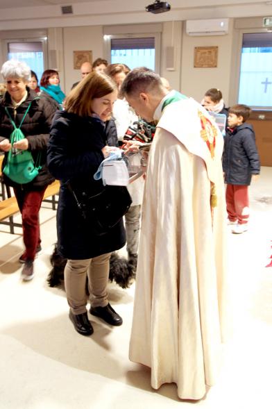 Bendición de Animales por San Antón en la Parroquia San Juan XXIII - Imagen de una persona acercando su perro para que el cura le bendiga.