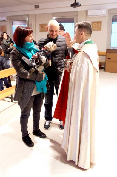 Bendición de Animales por San Antón en la Parroquia San Juan XXIII - Imagen de una persona acercando su perro para que el cura le bendiga.