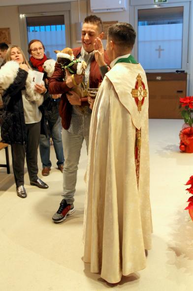 Bendición de Animales por San Antón en la Parroquia San Juan XXIII - Imagen de una persona acercando su perro para que el cura le bendiga.