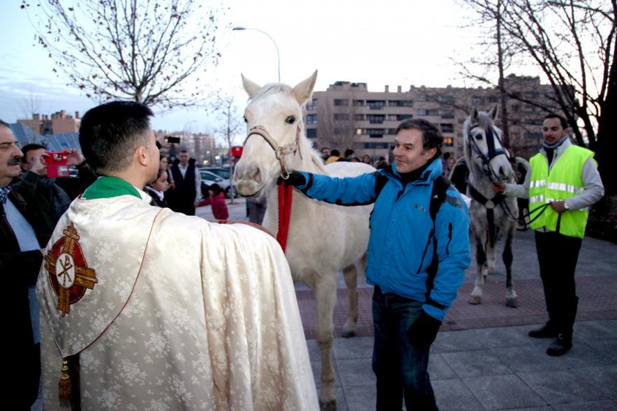 Bendición de Animales por San Antón en la Parroquia San Juan XXIII -Imagen del cura en el exterior de la iglesia bendiciendo a un caballo.
