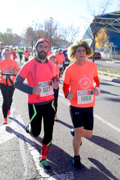 San Silvestre 2018 - Primer plano de dos  corredores, uno con peluca.