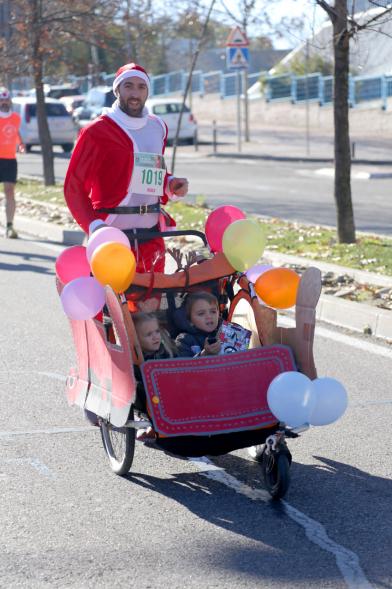 San Silvestre 2018 - Imagen de un  corredor disfrazado de Papá Noel, empujando el carrito de sus hijos.