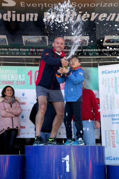 San Silvestre 2018 - Pódium de Ramón Cubián,  concejal  de desarrollo y un niño, celebrando.