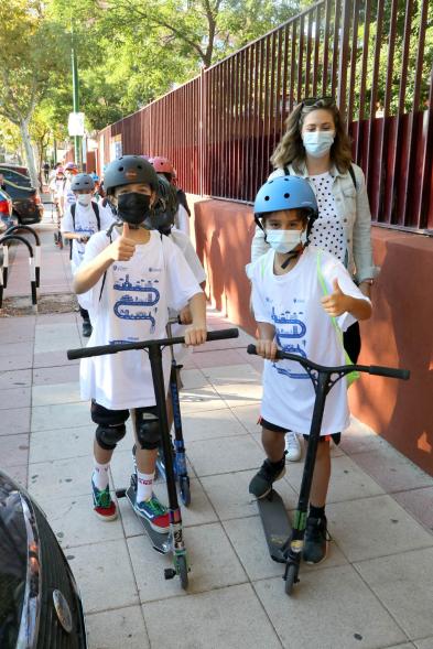 Alumnos en patinete saludan a la cámara