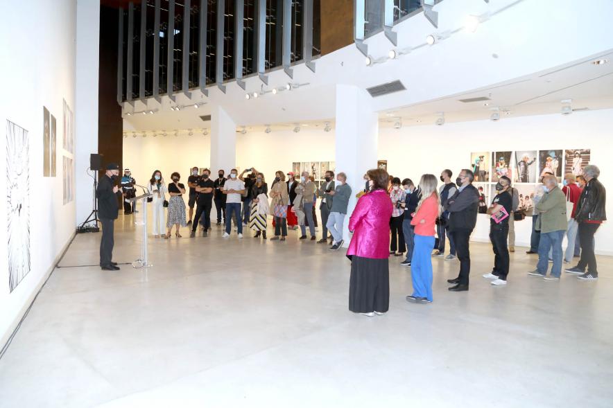 Inauguración Exposición Miguel Trillo - Imagen lejana del fotógrafo Miguel Trillo dirigiéndose al público asistente a la inauguración.