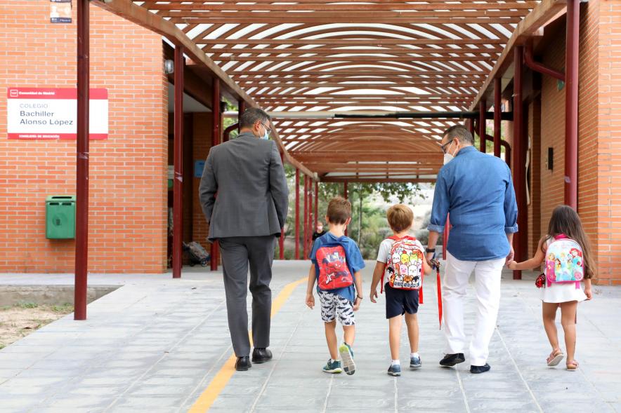 Inicio del Curso Escolar 2020-21 - Imagen del alcalde Rafael Sánchez Acera y un responsable del centro entrando con los alumnos más pequeños.