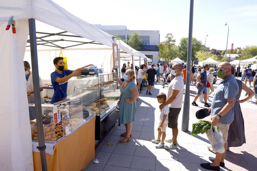 Mercado Ecológico en el Paseo Valdelasfuentes - Imagen de personas comprando en un puesto de repostería artesana.