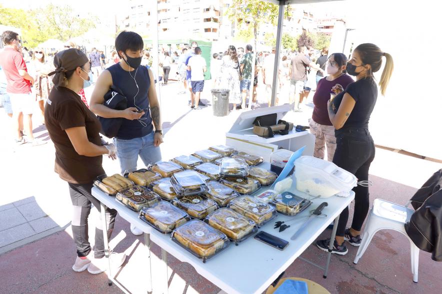 Mercado Ecológico en el Paseo Valdelasfuentes - Imagen de personas comprando en un puesto de repostería artesana.