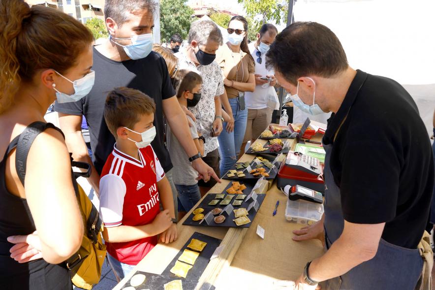 Mercado Ecológico en el Paseo Valdelasfuentes - Imagen de personas comprando en un puesto de pasta fresca.