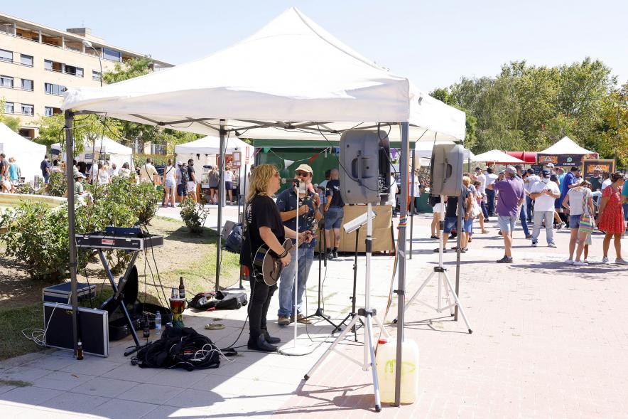     Mercado Ecológico en el Paseo Valdelasfuentes - Imagen de personas disfrutando de la música en vivo durante la hora del aperitivo.