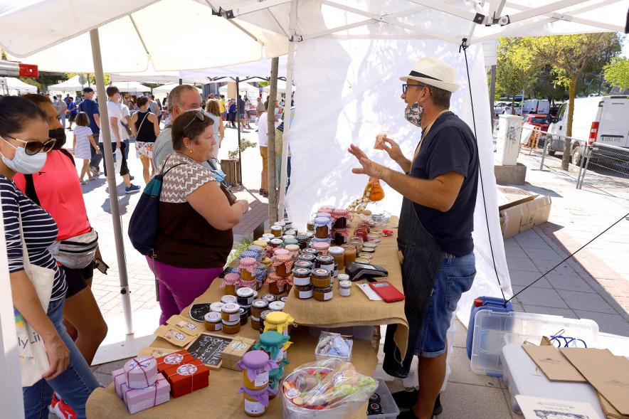  Mercado Ecológico en el Paseo Valdelasfuentes - Imagen de personas comprando en un puesto de mermeladas caseras.