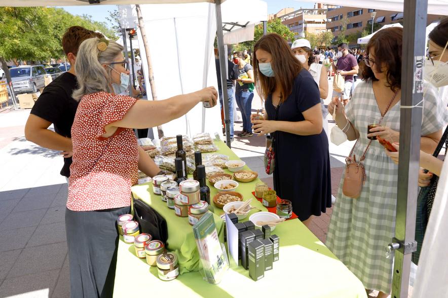 Mercado Ecológico en el Paseo Valdelasfuentes - Imagen de personas comprando en un puesto de conservas.