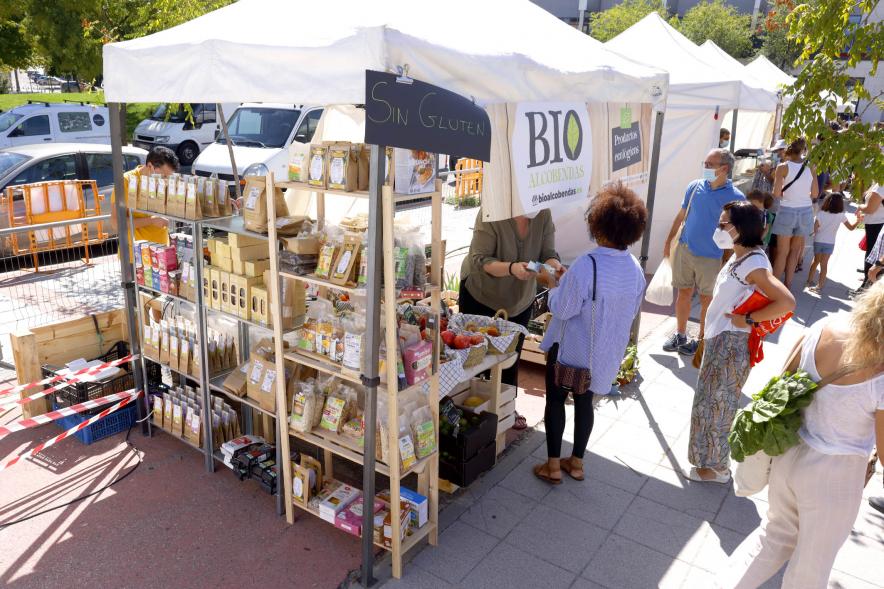 Mercado Ecológico en el Paseo Valdelasfuentes - Imagen de personas comprando en un puesto de productos ecológicos en general.