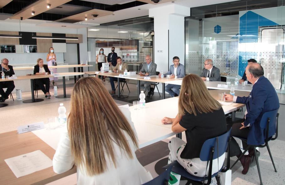 Visita a Montajes Delsaz y Encuentro con Embajadores Empresariales -  Imagen de las autoridades asistentes al acto en una sala de reuniones recibiendo una charla.