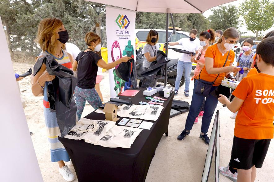 Reciclaje y Recogida de Residuos en la Moraleja Pony Club - Imagen de un stand donde se reparten bolsas de basura, guantes, etc.
