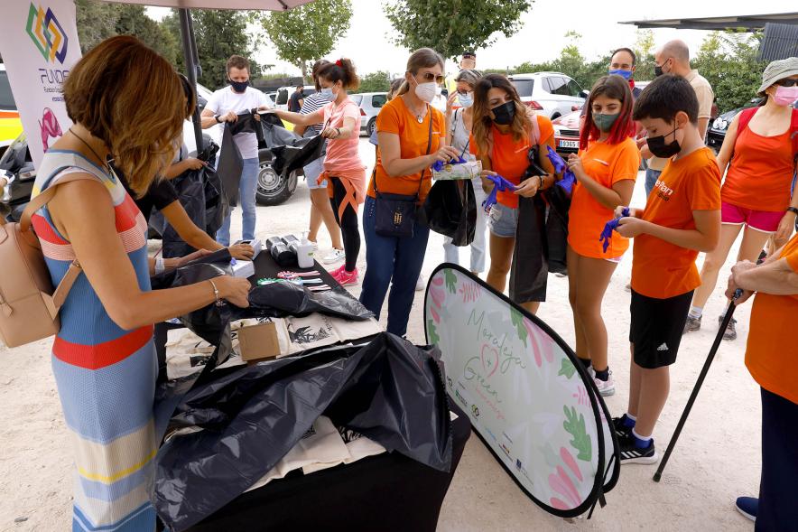 Reciclaje y Recogida de Residuos en la Moraleja Pony Club - Imagen de un stand donde se reparten bolsas de basura, guantes, etc.