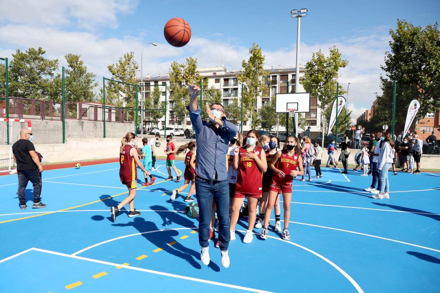 Inauguración Pista Deportiva Fuentelucha - Imagen del alcalde Rafael Sánchez Acera practicando el tiro de baloncesto con jóvenes.