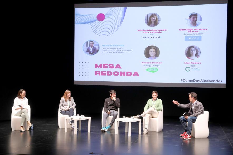  Acto Final StartUp Alcobendas - Imagen del Concejal Roberto Fraile y los componentes de la mesa redonda en el escenario.
