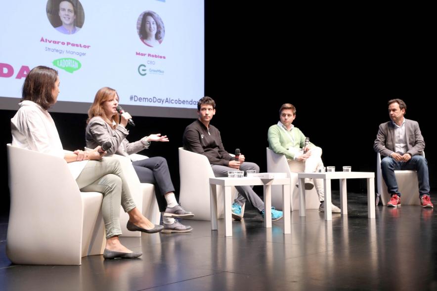  Acto Final StartUp Alcobendas - Imagen del Concejal Roberto Fraile y los componentes de la mesa redonda en el escenario.