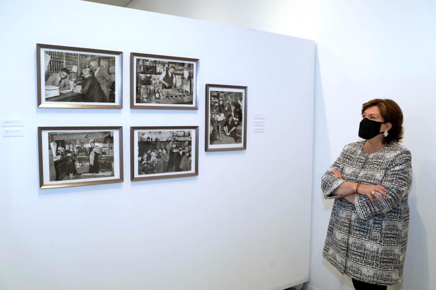 Inauguración Exposición 'Oficio de Vivir' - Imagen de la concejala de cultura Rosario Tamayo posando junto a unas fotografías.