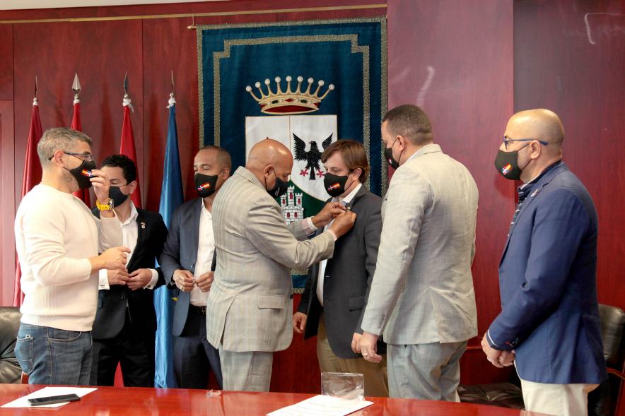 Bienvenida Delegación República Dominicana - Imagen de un miembro de la delegación República Dominicana colocando un insignia a una de las autoridades de Alcobendas.
