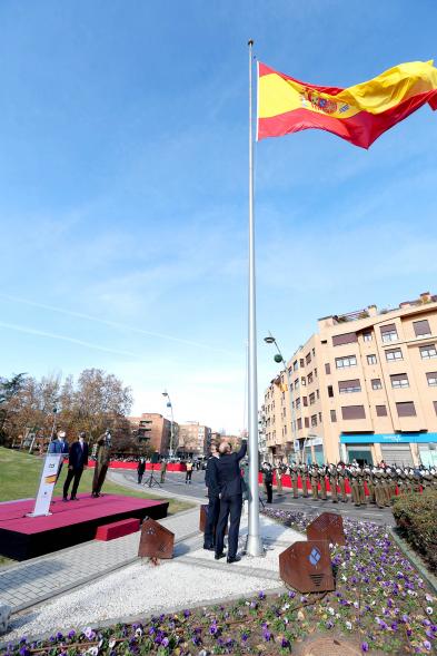 Bandera ondeando en lo alto del mástil con edificio al fondo