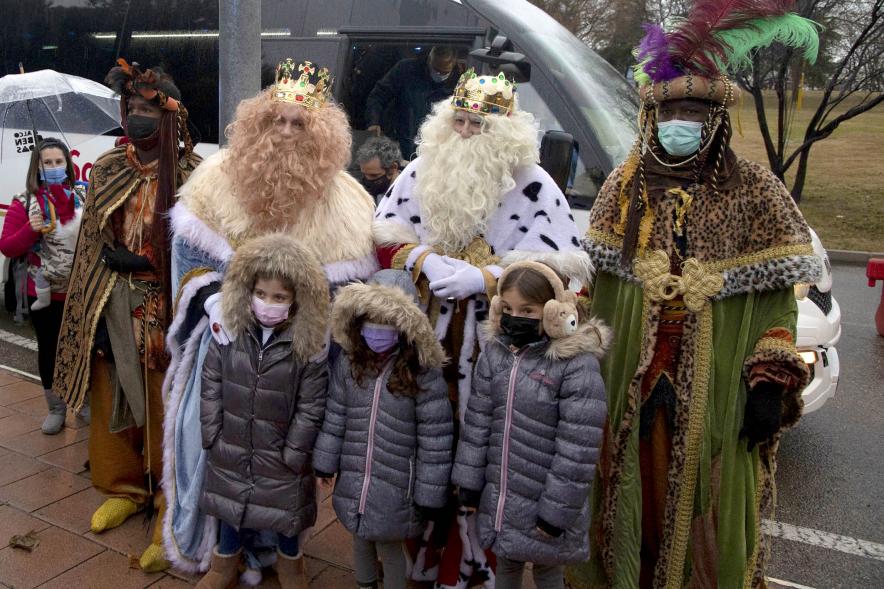 Cabalgata de Reyes 2022 -  Imagen de los tres Reyes Magos posando con unas niñas.