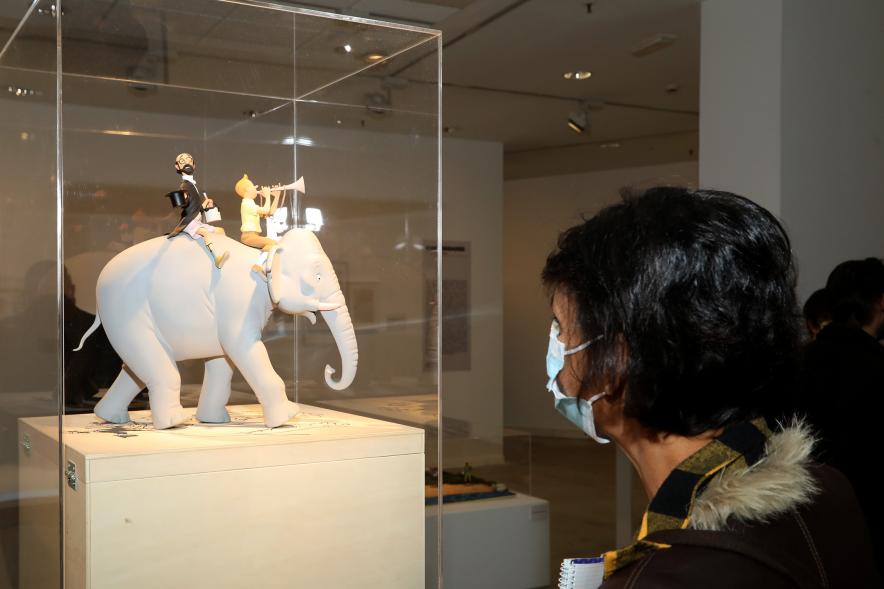   Inauguración Exposición "Miradas Tintinófilas" - Imagen de una persona mirando uno de los objetos de "Tintín" de Hergé que se exponen.