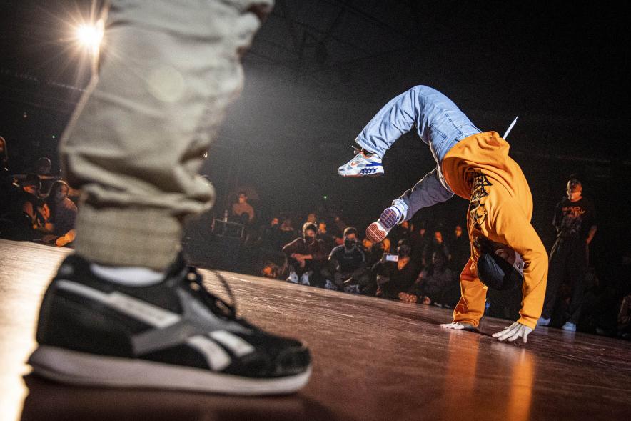  A Ras de Suelo - Breakdance - Imagen de un joven realizando un  movimiento de Breakdance.