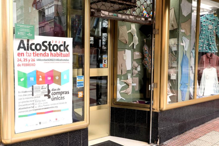 Fachada de comercio con cartel promocional de Alcostock