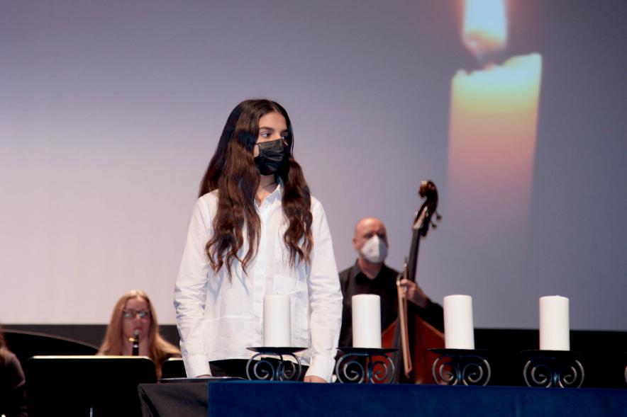 Acto Día de la Memoria del Holocausto 2022 -  Primer plano  de una alumna  frente a las velas del homenaje.